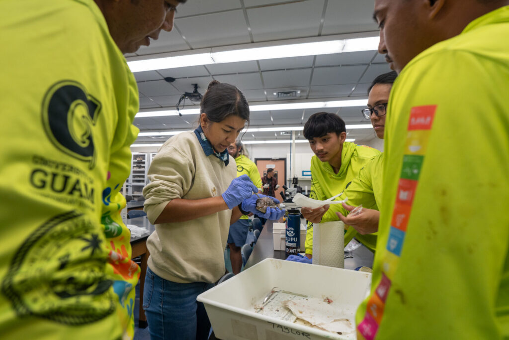 Leilani Sablan-Naden shows G3CC members how to properly extract otoliths from a fish.