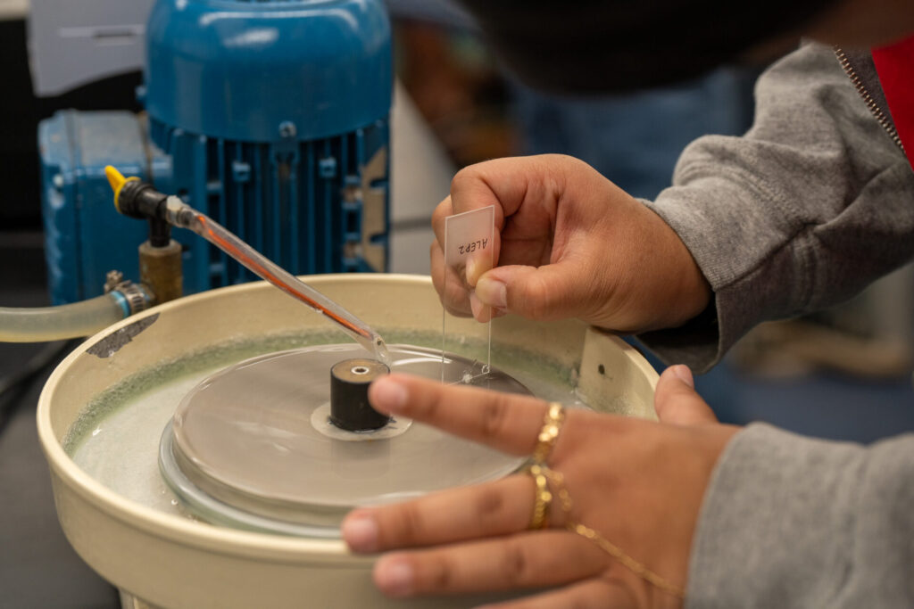 A member of the G3CC grinds down an otolith mounted to a microscope slide.