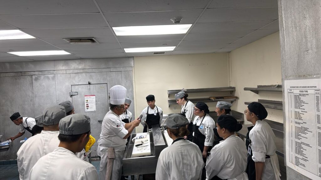 ProStart coach and mentor Chef Poul walks GCC ProStart culinary students through preparation work that has begun for Maila’ Ta Fan Chesa.  The event happens on Thursday, September 17 at 6pm at the Hyatt Regency Guam and will feature local chefs and students showcasing their skills and local produce grown by farmers.
