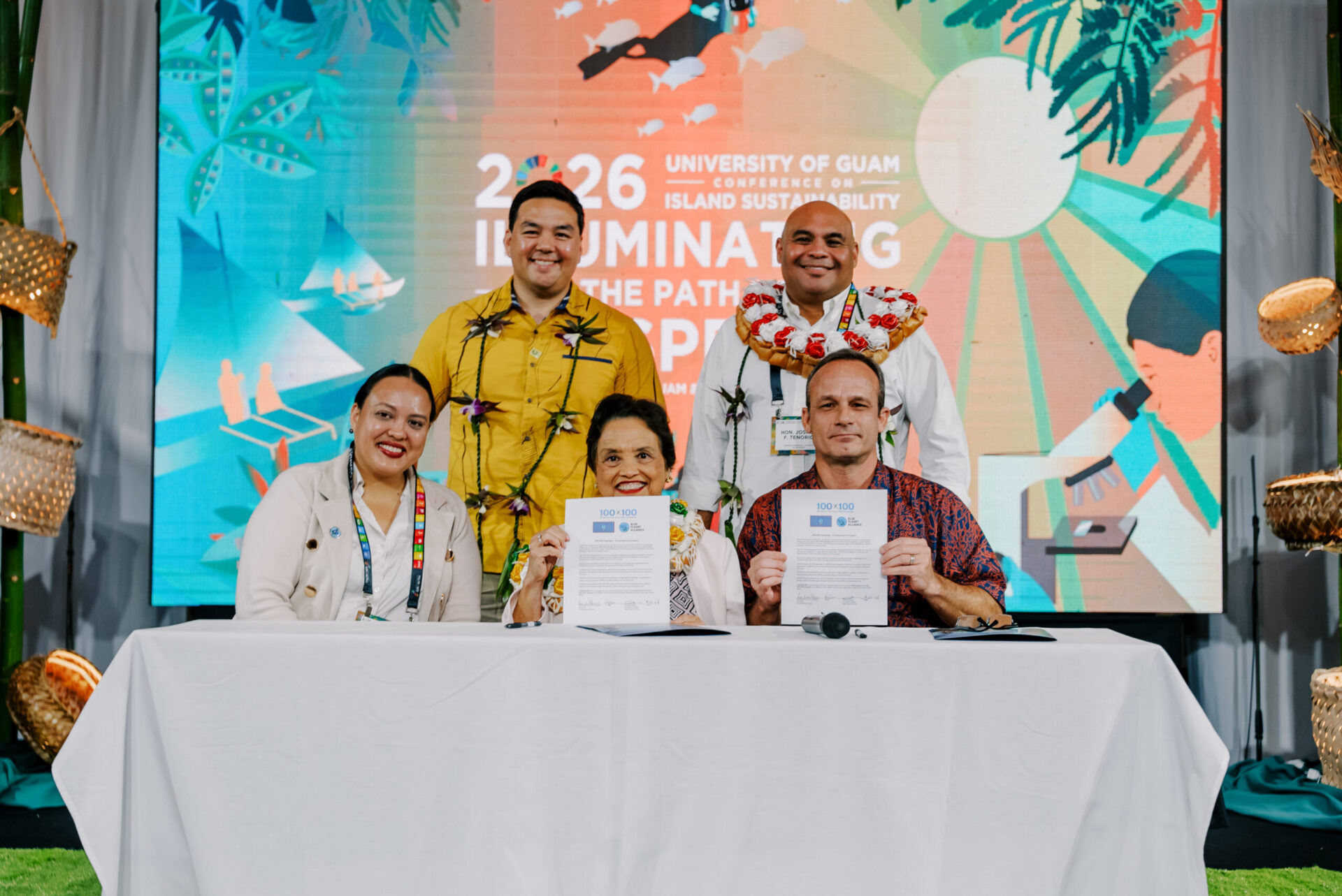 Gov. Lou Leon Guerrero, Lt. Gov. Josh Tenorio, and Francois Rogers hold signed documents at the 17th UOG Conference on Island Sustainability.