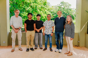 A group of six University of Guam leaders, faculty researchers, and student interns standing side-by-side outdoors, posing for a photo following the announcement of the inaugural Guam NSF EPSCoR E-CORE seed funding awards.