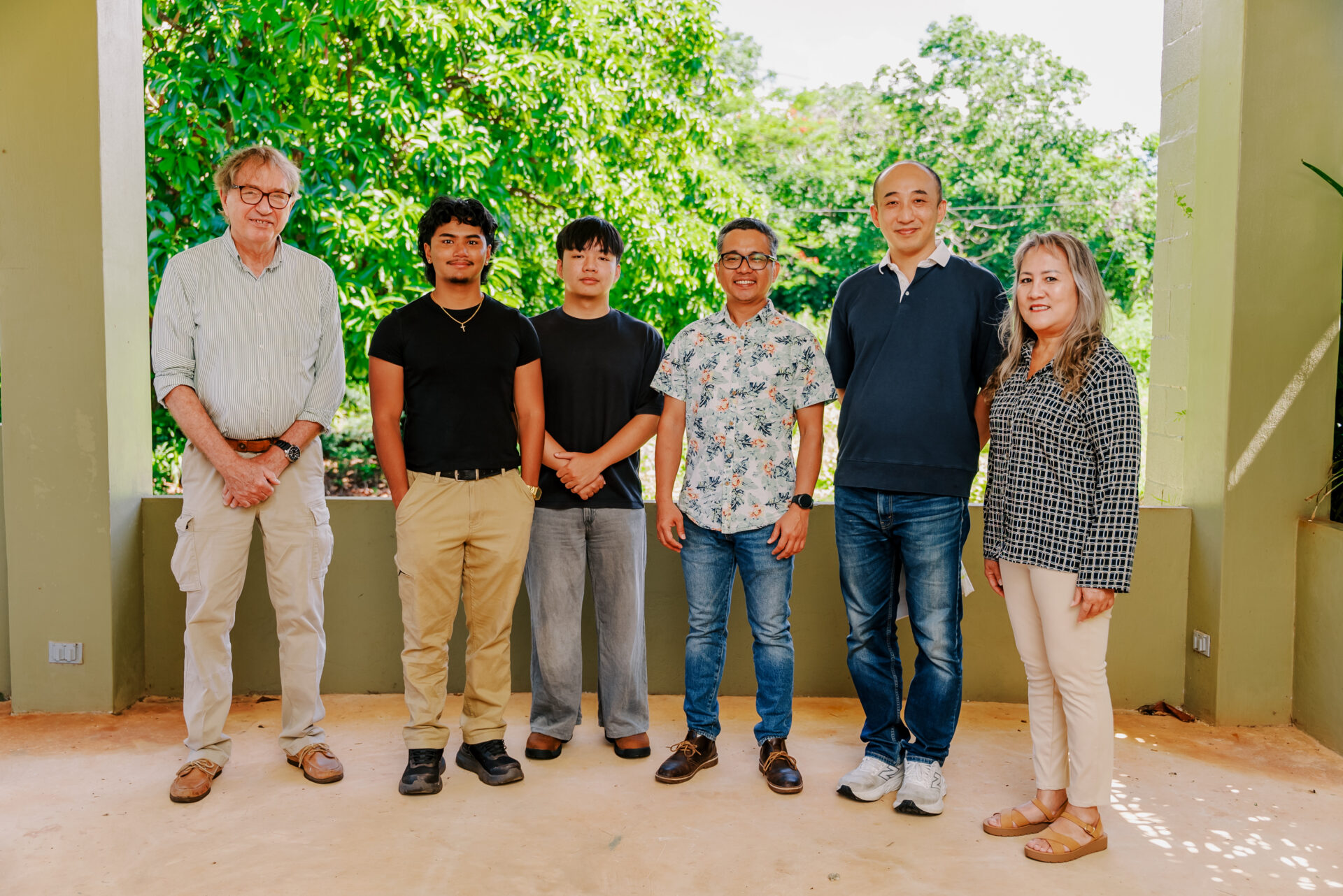 A group of six University of Guam leaders, faculty researchers, and student interns standing side-by-side outdoors, posing for a photo following the announcement of the inaugural Guam NSF EPSCoR E-CORE seed funding awards.