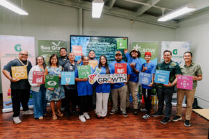 The second G3 GROW Corps cohort and UOG CIS & Sea Grant leadership pose holding colourful Sustainable Development Goal signs and a Guam Green Growth plaque.