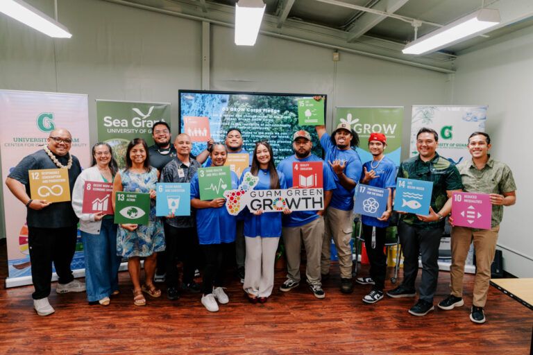 The second G3 GROW Corps cohort and UOG CIS & Sea Grant leadership pose holding colourful Sustainable Development Goal signs and a Guam Green Growth plaque.